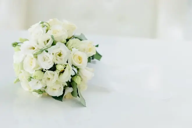 Bridal bouquet of pink and white flowers resting on a wooden table
