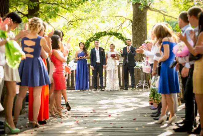 Couple at an outdoor summer wedding with shade structures and cold drinks