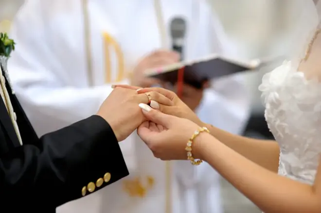 Couple standing at the altar during their wedding ceremony with soft natural light