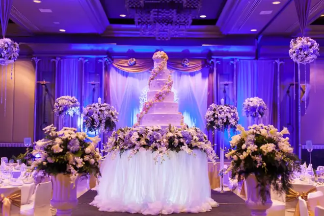 Elegantly decorated custom wedding cake with fresh flowers on a reception table