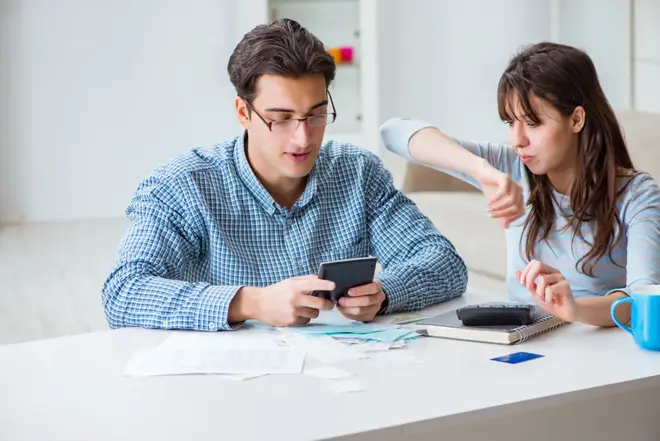Couple sitting together reviewing wedding planning documents and ideas at a table