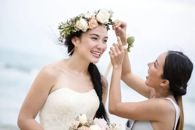Bride and maid of honor laughing together while getting ready before a city hall wedding ceremony