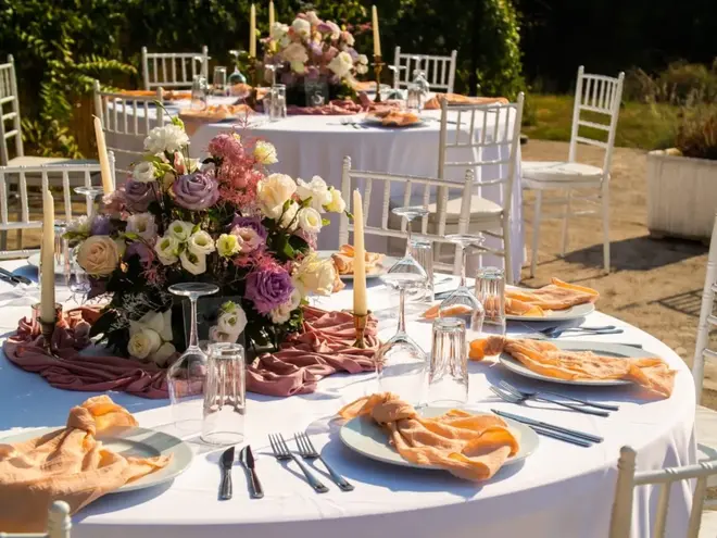 Wedding reception table with a cohesive color palette featuring floral centerpieces, candles, and coordinated table linens