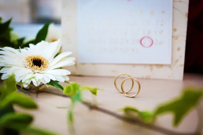Couple reviewing wedding planning checklist together at a kitchen table