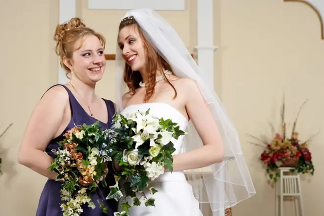 Maid of honor helping the bride adjust her veil before a city hall wedding ceremony