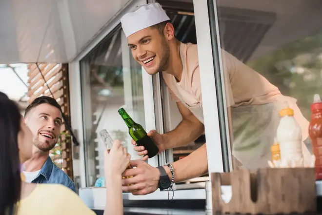 Wedding guests ordering from a food truck parked at an outdoor reception venue