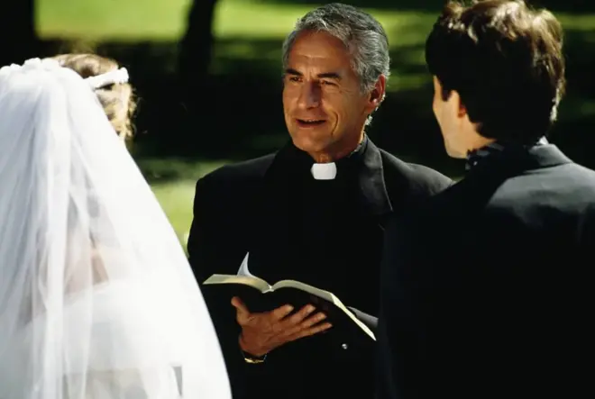 A wedding officiant standing with a couple during a ceremony at city hall